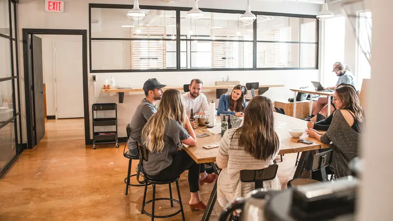 Grupo de empreendedores reunidos em volta de uma mesa em espaço de trabalho